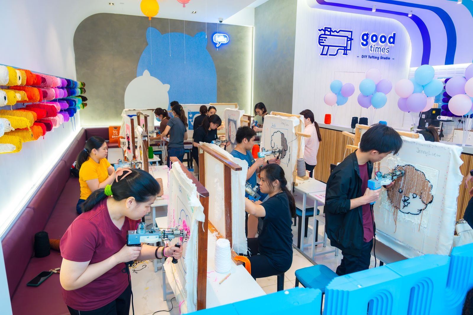 Customers tufting at frames in a bright Good Times tufting studio
